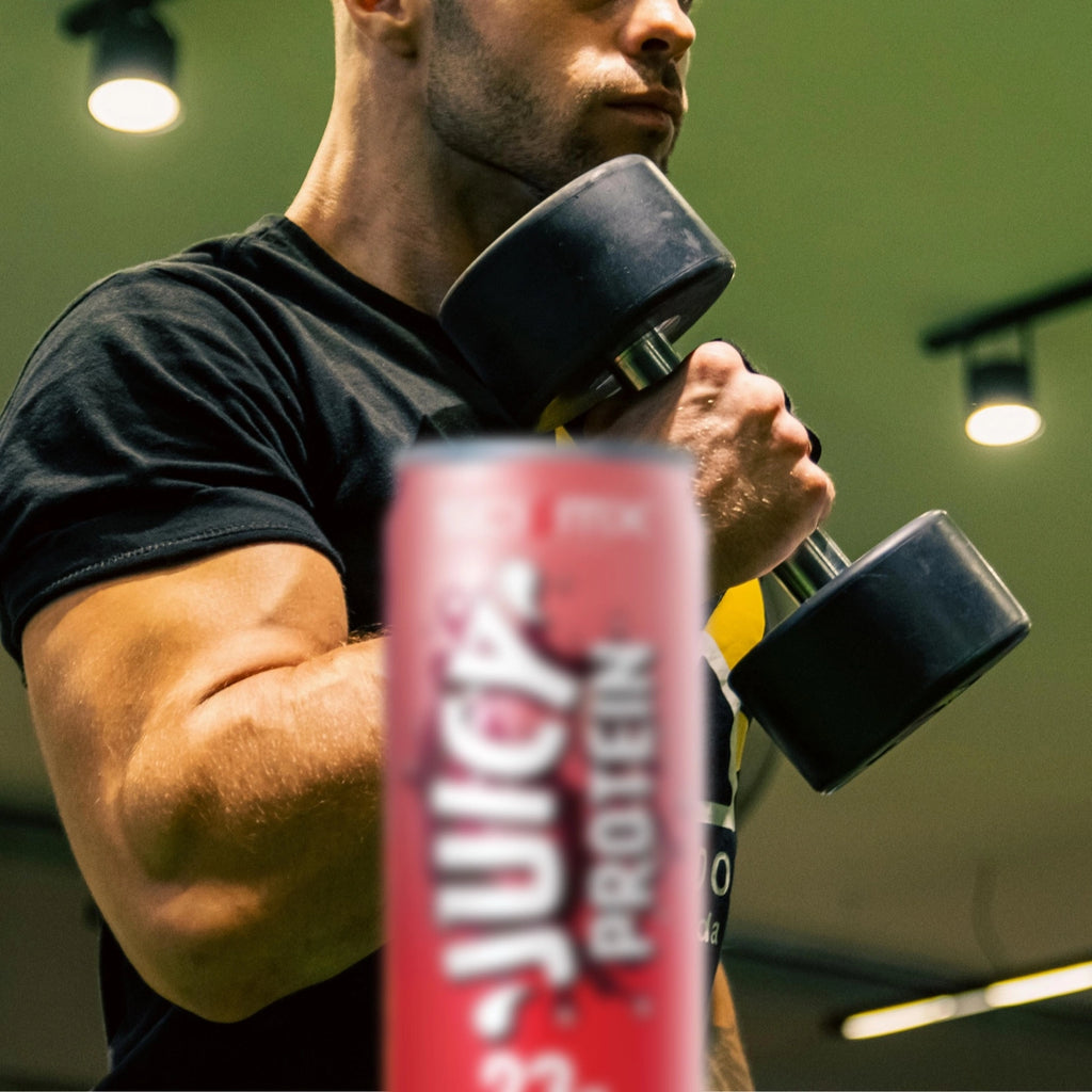 Person lifting dumbbells with a can of Juicy Protein in the foreground.
