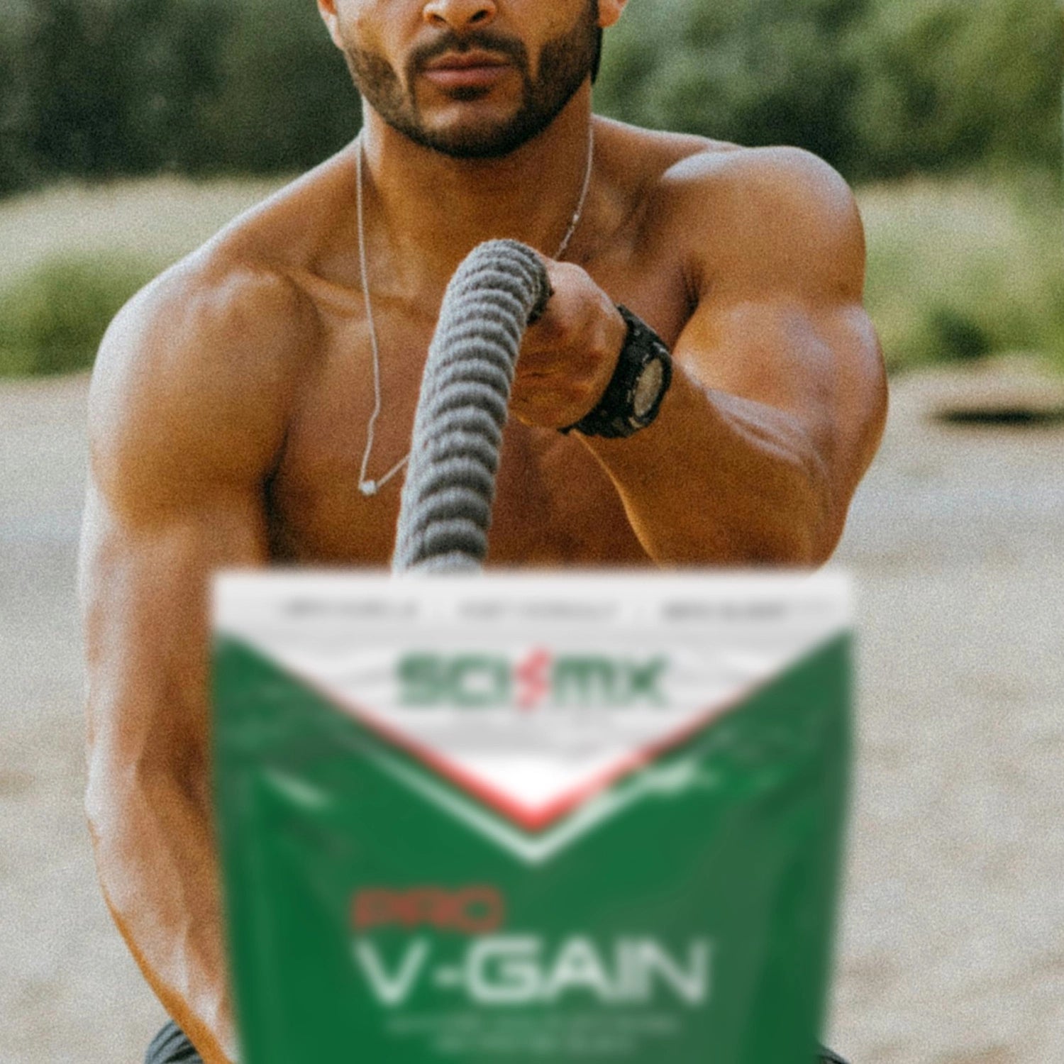 Man exercising outdoors with a SCI-MX 'Pro V-Gain' supplement package in the foreground