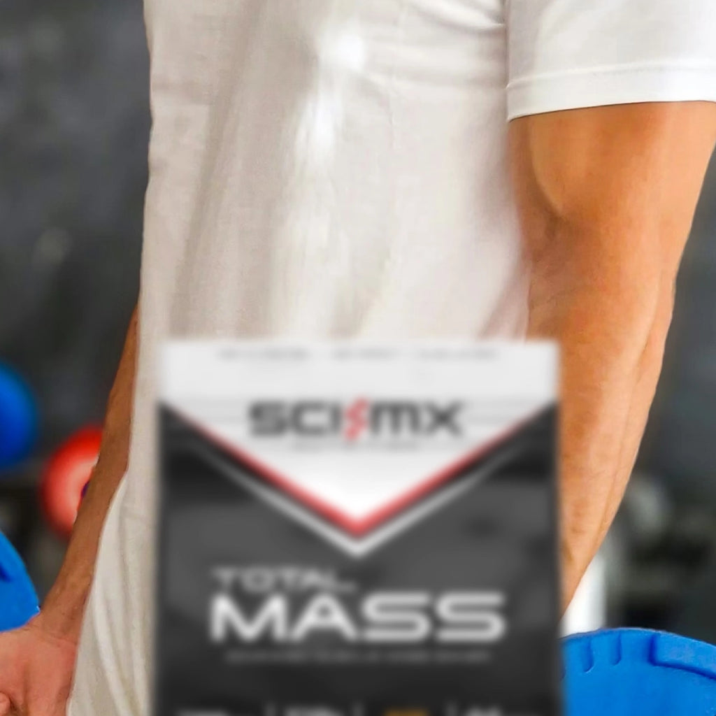 Man training with a barbell with Total Mass Strawberry flavour in the foreground