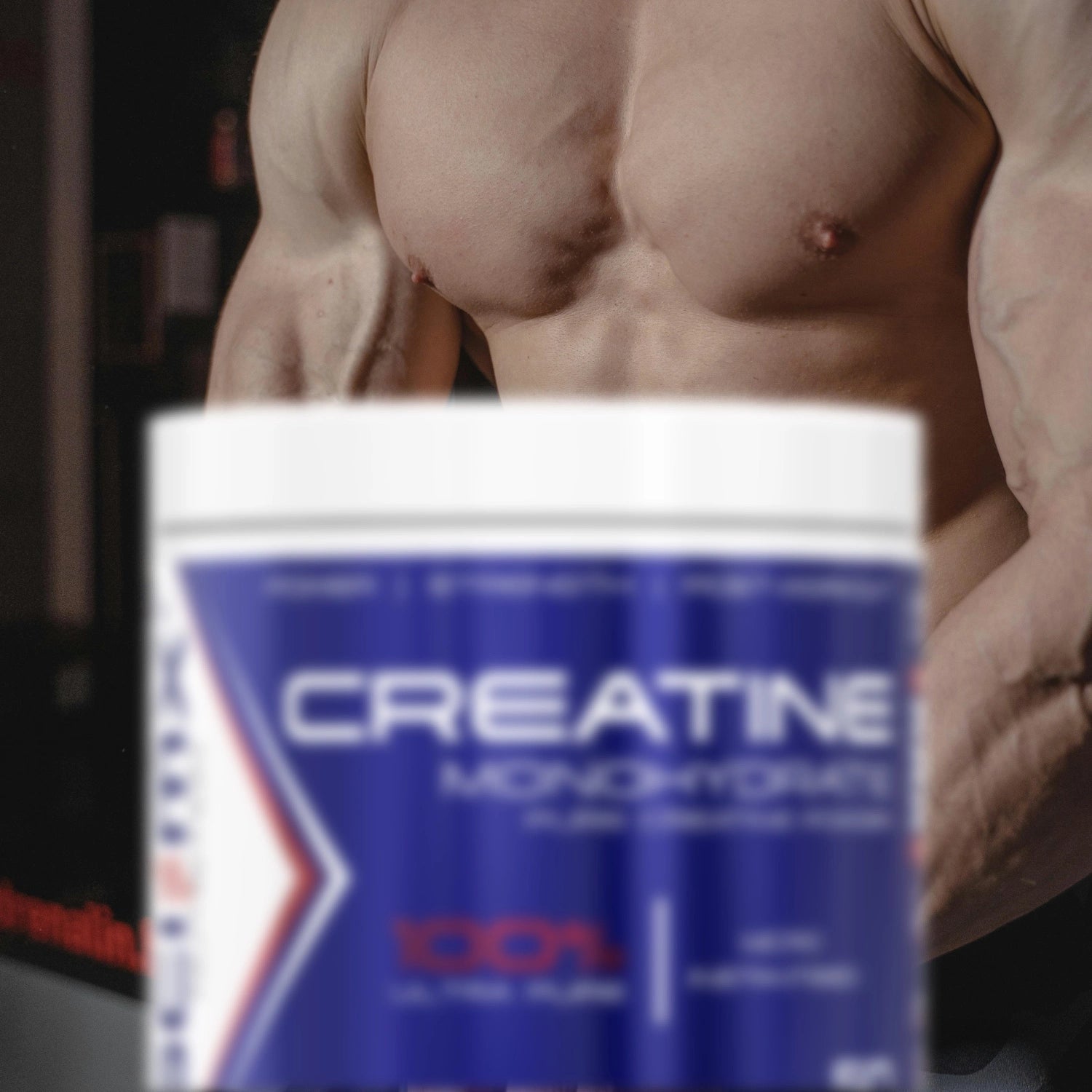 Container of creatine monohydrate powder with a blurred background of a muscular man