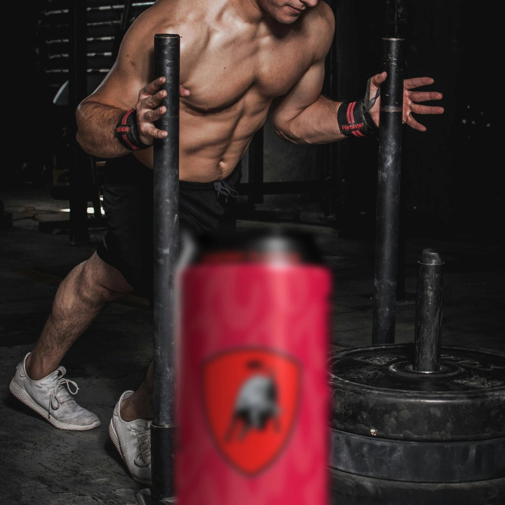 Muscular man lifting weights in a gym with a Tonino Lamborghini Energy Drink in the foreground