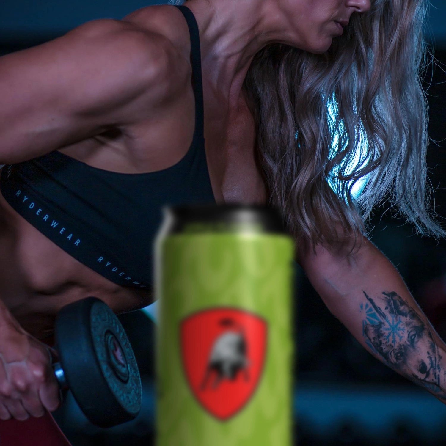 A woman lifting weights with a can of Lamborghini Energy drink featuring a logo in the foreground