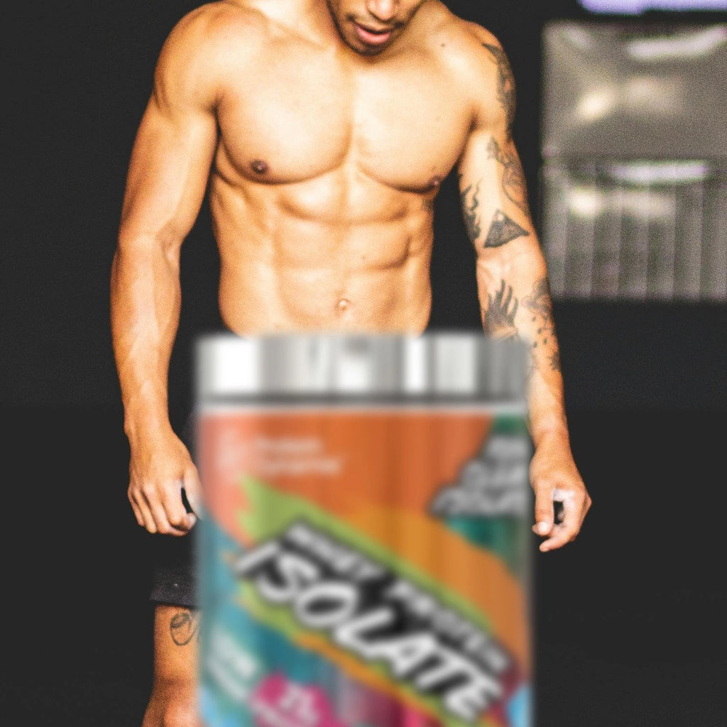 Man with muscular build in gym with a container of Whey Protein Isolate against a dark background
