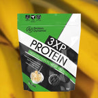 Protein Dynamix 3XP Protein package on a blurred banana background