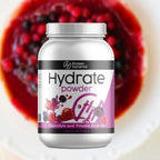 Protein Dynamix Hydrate powder container with mixed berries in the background