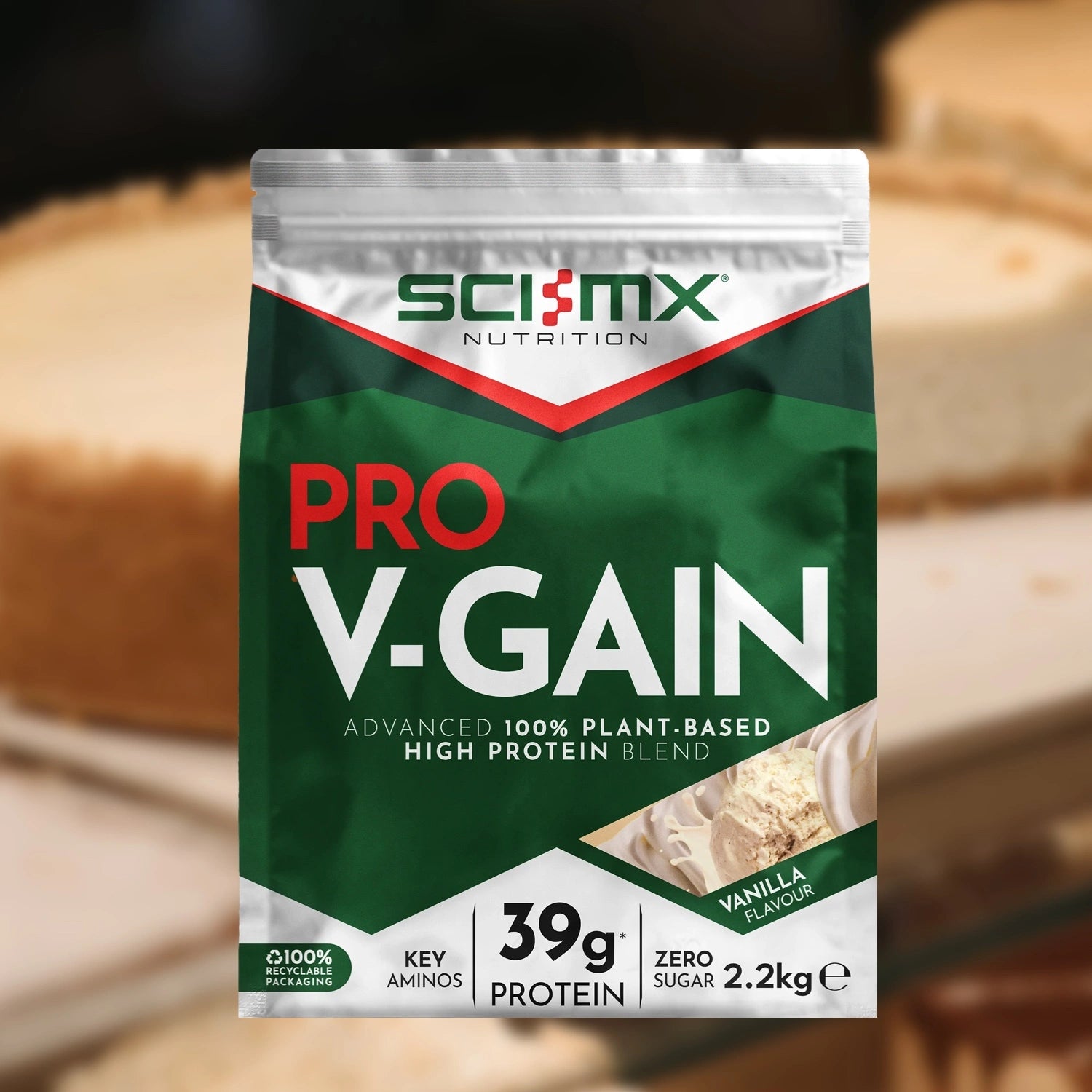 Sci-Mx Nutrition Pro V-Gain Vanilla protein package with Vanilla Cheesecake in the background