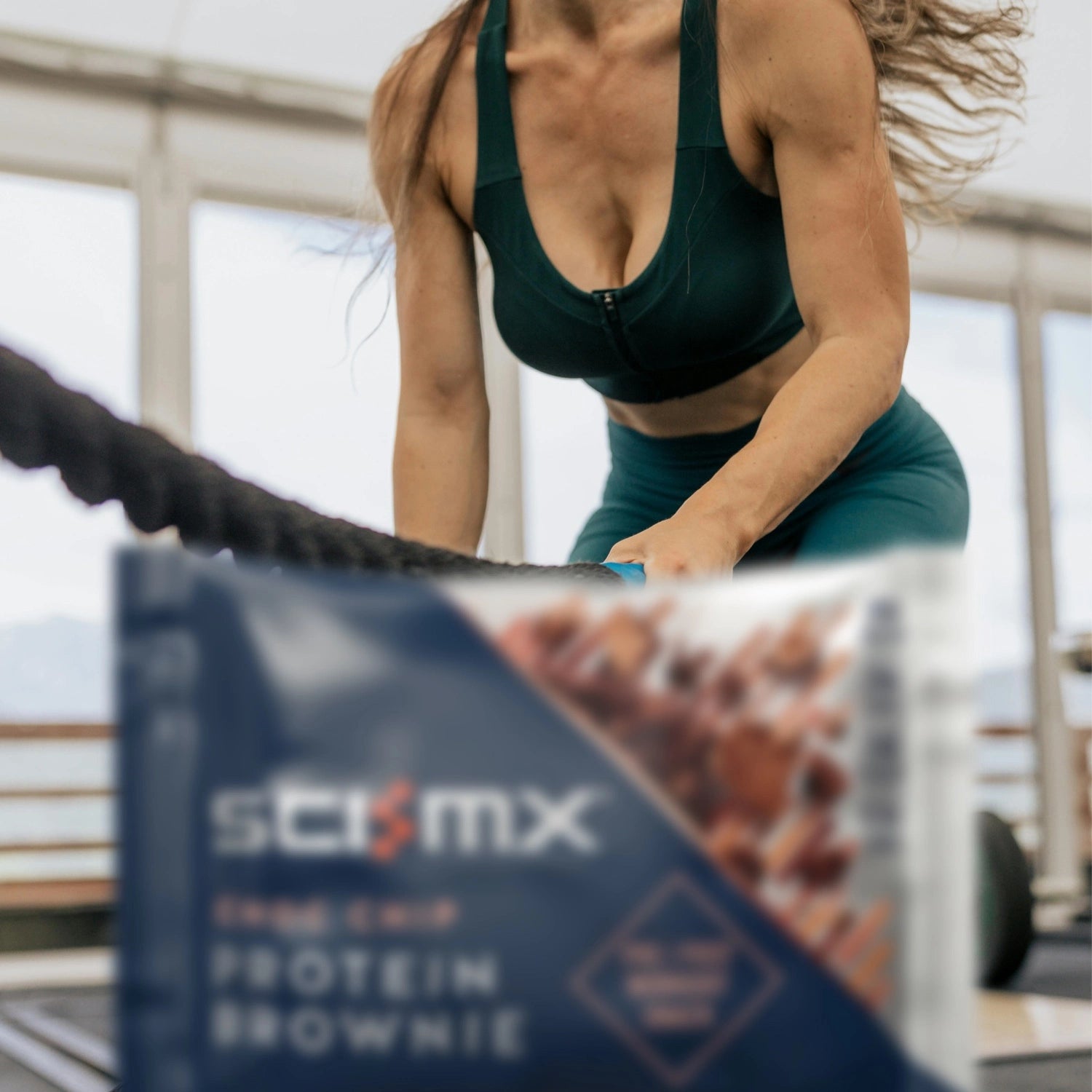 Person exercising with a protein brownie package in the foreground