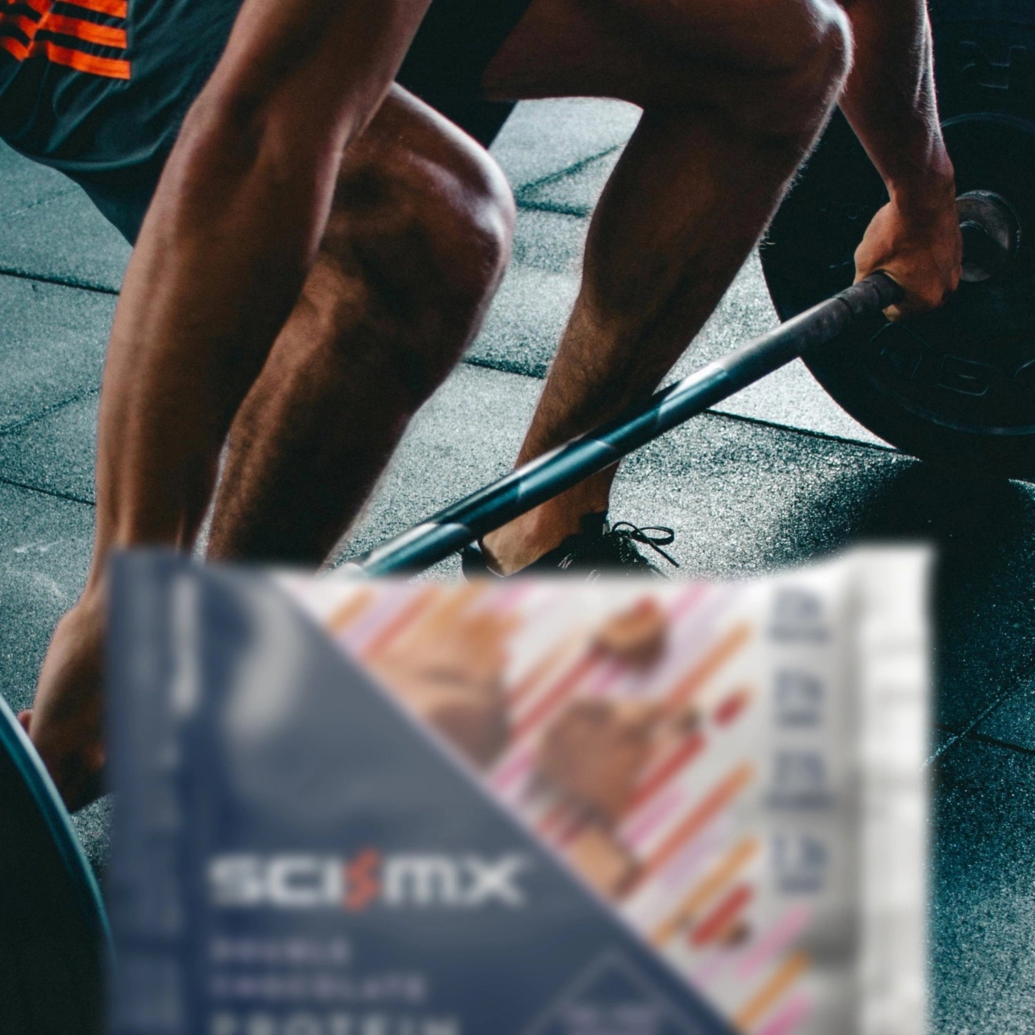 Person lifting weights with Scivation protein package in foreground